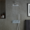 Moderne inbouw doucheset met chroom afwerking, thermostaatkraan en regendouche, gemonteerd op een grijze marmeren badkamerwand met nis en handdouche.