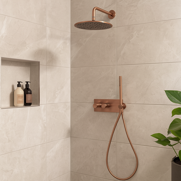 Moderne inbouw doucheset met ronde regendouche en handdouche in geborsteld brons, gemonteerd tegen een lichte marmeren wand in een stijlvolle badkamer.