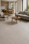 Slab tegel Newstone Grey 100x300 cm met voegloos design in een moderne woonkamer met veel natuurlijk licht en houten interieurdetails.