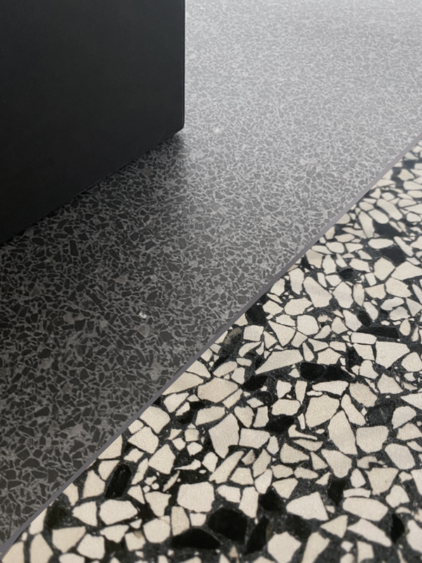 Close-up van twee varianten Class Terrazzo Fusina rec 60x60cm terrazzo tegels keramische, met donkergrijs en wit patroon, ideaal als vloertegels binnen en buiten.