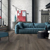 Woonkamer met keramisch parket Poetry Mud 30x120 cm in warme houtlook; modern interieur met blauwe bank en veel daglicht.