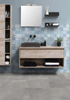 Mystone Fog grijze keramische vloertegels in een moderne badkamer met houten wastafel, blauwe wandtegels en strakke accessoires, ideaal voor badkamer en vloer.