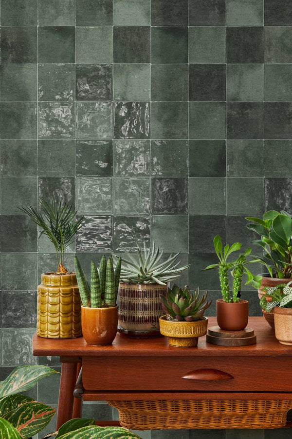 Zellige tegels Class Zellige Verde Oscuro 10x10 cm als groene wandtegel met glanzende afwerking achter houten tafel met retro plantenpotten